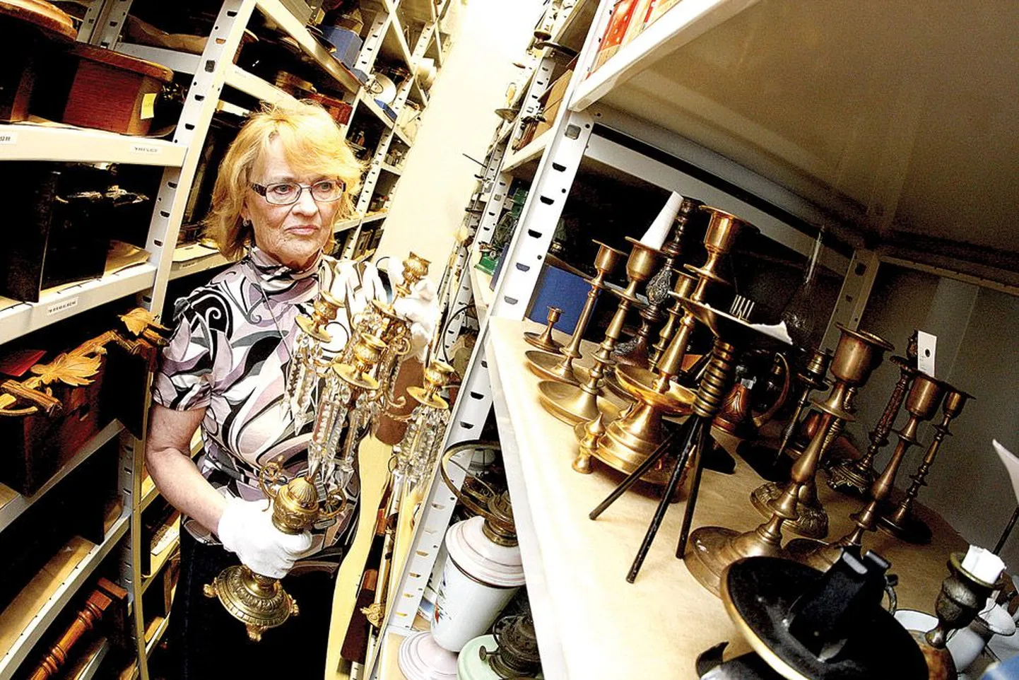 Fondist valib valgusteid linnamuuseumi saalidesse teadur-koguhoidja Aime Kärner. Ta on riiulilt võtnud 19. sajandi kandelaabri, mis on valmistatud ilmselt Peterburis.