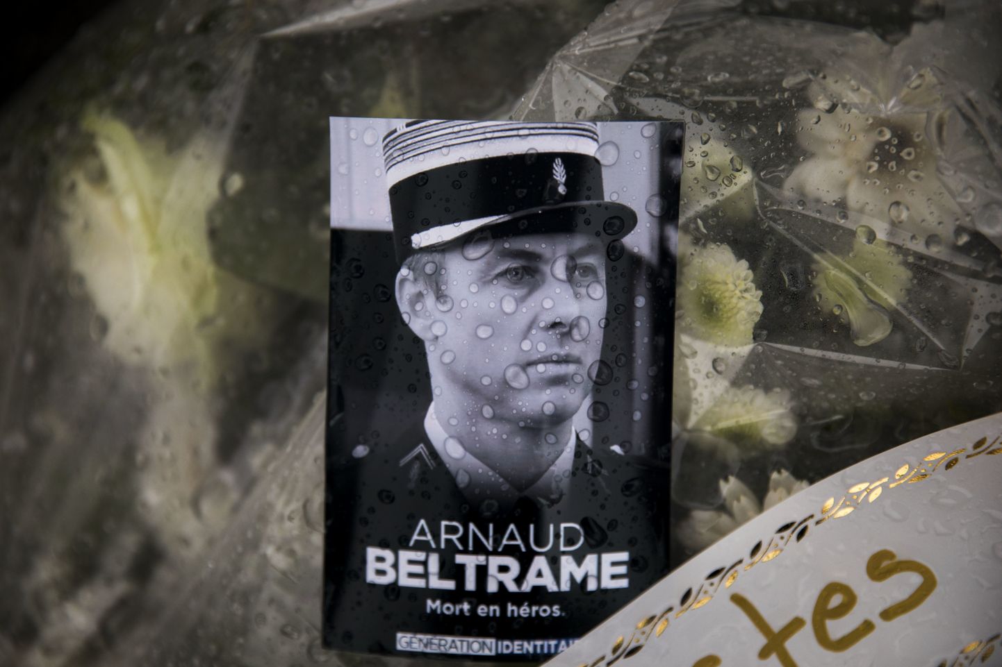 Politseikolonelleitnant Arnaud Beltrame' foto, mis on asetatud lillekimbu peale.