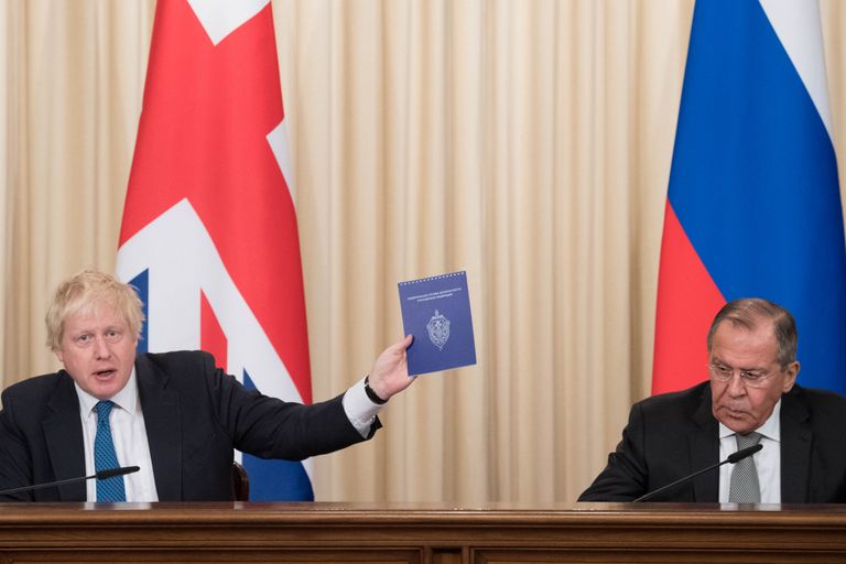 Boris Johnson hoidmas FSB logoga väljaannet. Paremal Venemaa välisminister Sergei Lavrov.