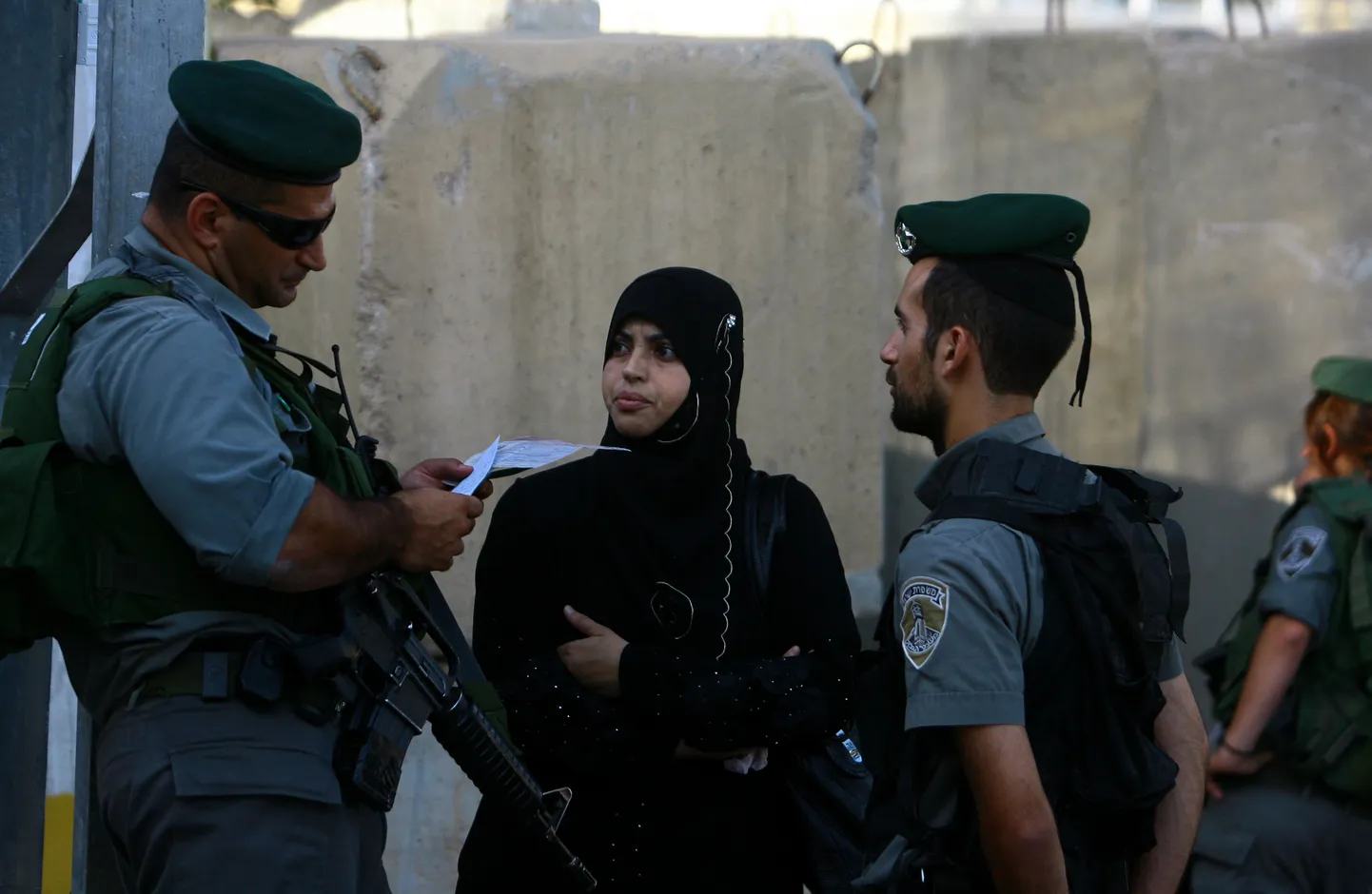 Iisraeli piirivalvur kontrollib Petlemmas palestiina naise dokumente.