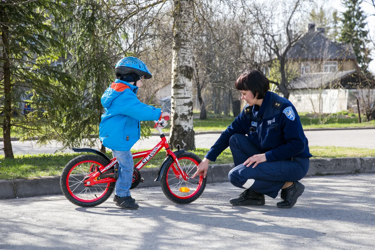 Noorsoopolitseinik Malle Hermanson kontrollib lapse jalgratta korrasolekut.
