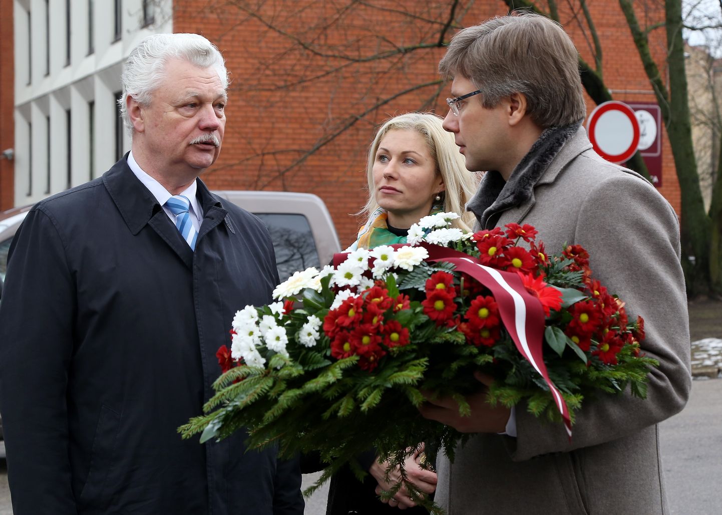 Nils Ušakovs (no labās), Iveta Strautiņa-Ušakova un Dainis Turlais piedalās ziedu nolikšanas ceremonijā pie pieminekļa Klusajā dārzā, pieminot Afganistānas karā kritušos Latvijas iedzīvotājus.
