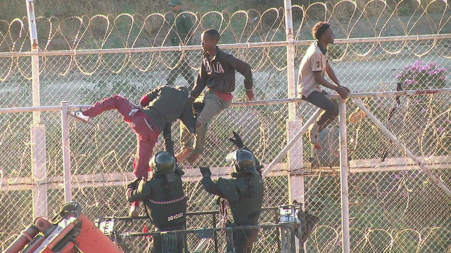 Migrandid ületamas Marokot ja Hispaania Ceuta enklaavi eraldavat piiritara.