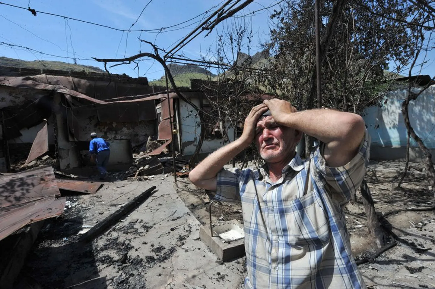 Kõrgõzstani lõunaosas Ošis elav usbekk eile oma mahapõlenud kodu varemete ees.