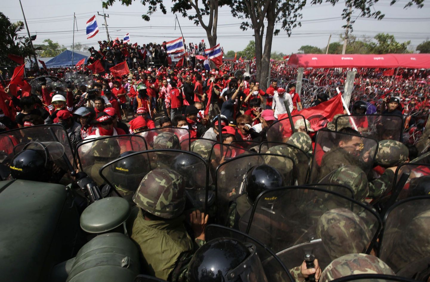 Tai punasärkides opositsiooni meeleavaldajad võitlemas sõduritega Thaicom Teleporti kompleksi juures Bangkoki põhjapoolses eeslinnas.