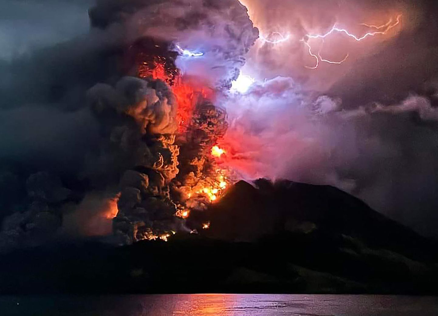 Indoneesias Ruangi vulkaanist välja valguv laava ja kerkiv suits ööl vastu tänast.
